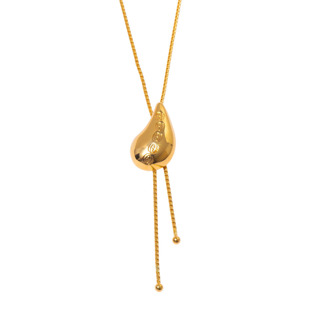 Colar gravatinha gota abaulada com logo Herreira em relevo e banho de ouro 18k. Design autoral, produção própria em Goiânia.